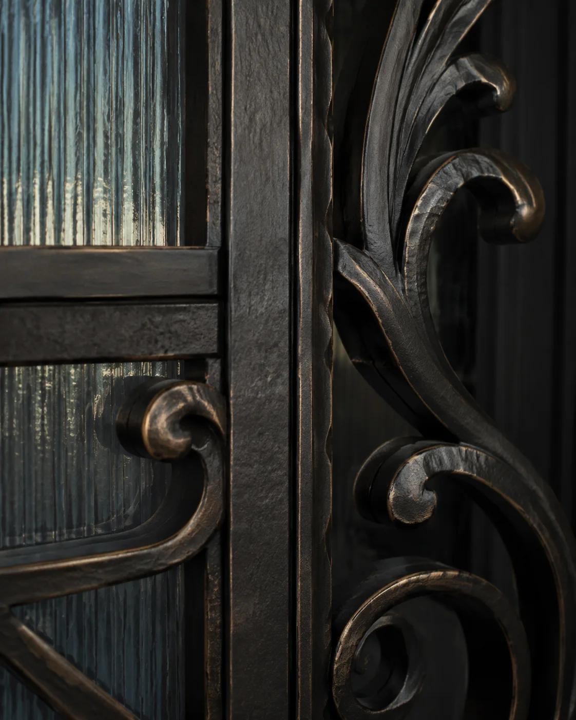 Concept detail of sculpted iron scrollwork and warm metallic edges